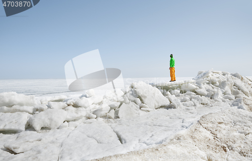 Image of Young adult man outdoors exploring icy landscape