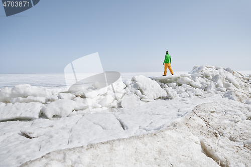 Image of Young adult man outdoors exploring icy landscape