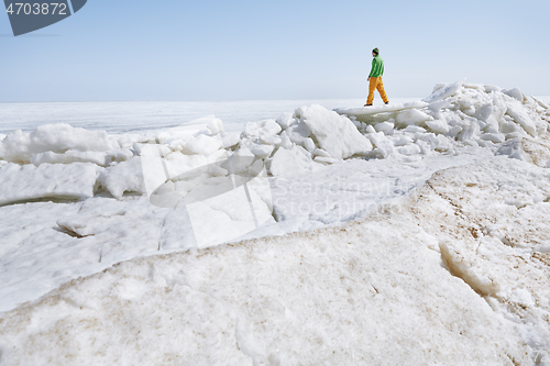 Image of Young adult man outdoors exploring icy landscape