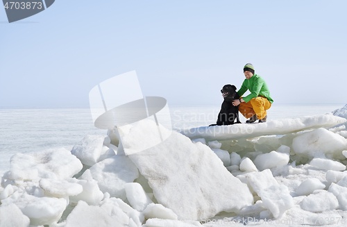 Image of Young adult man outdoors with his dog having fun in winter lands