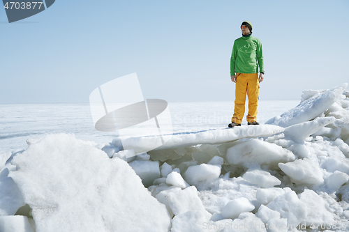 Image of Young adult man outdoors exploring icy landscape