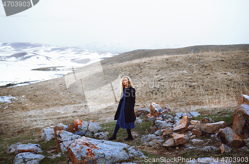 Image of Serious woman walking in the winter landscape