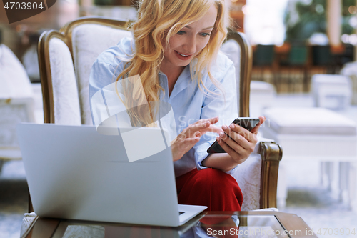 Image of Businesswoman using smartphone in the modern bank lobby