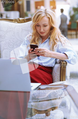 Image of Businesswoman using smartphone in the modern bank lobby