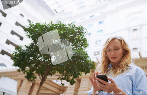 Image of Businesswoman using smartphone in the modern bank lobby