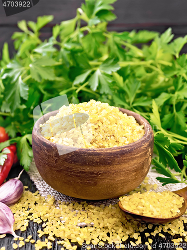 Image of Bulgur in bowl with vegetables on dark board