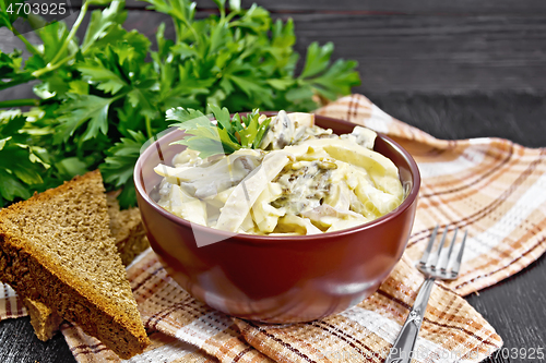 Image of Salad with squid and champignons in bowl on board