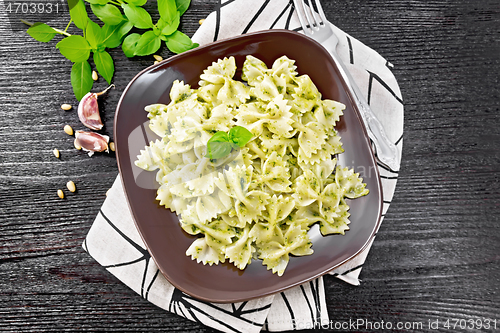 Image of Farfalle with pesto in plate on dark board top