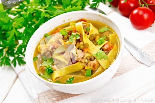 Image of Soup with mung and noodles in bowl on light board