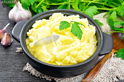 Image of Potatoes mashed in saucepan on dark board