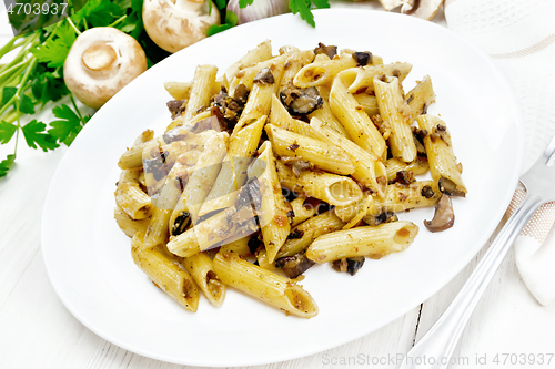 Image of Pasta with mushrooms in white plate on light board