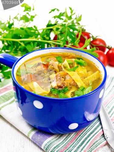 Image of Soup with mung and noodles in blue bowl on light board