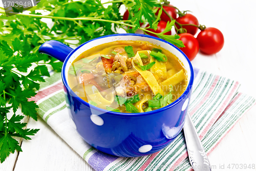 Image of Soup with mung and noodles in blue bowl on napkin