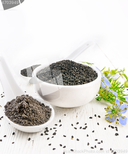 Image of Seeds of black cumin in bowl on light wooden board