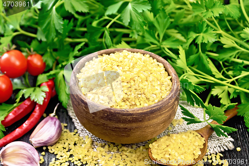 Image of Bulgur in bowl with vegetables on board