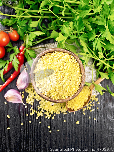 Image of Bulgur in bowl with vegetables on board top