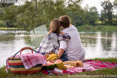 Image of Couple taking a selfie by mobile phone while enjoying picnic tim