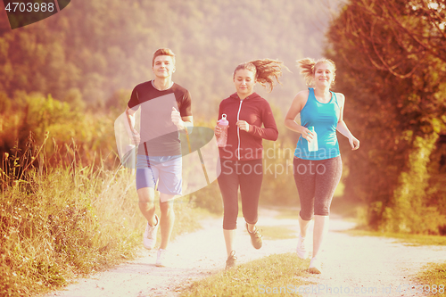 Image of young people jogging on country road