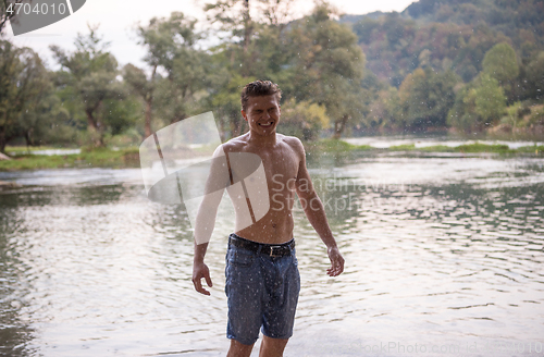 Image of man with a bare torso splashing water