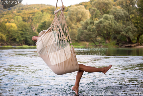 Image of blonde woman resting on hammock