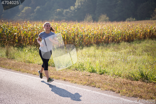 Image of woman jogging along a country road