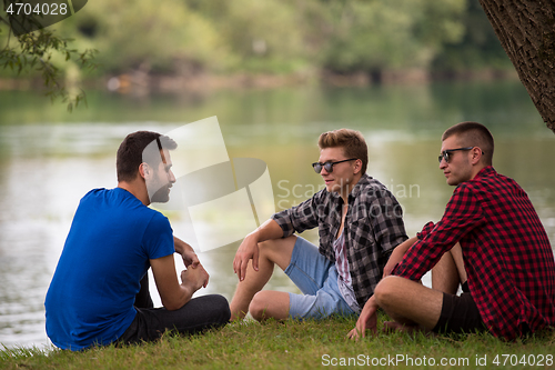 Image of men sitting on the bank of the river