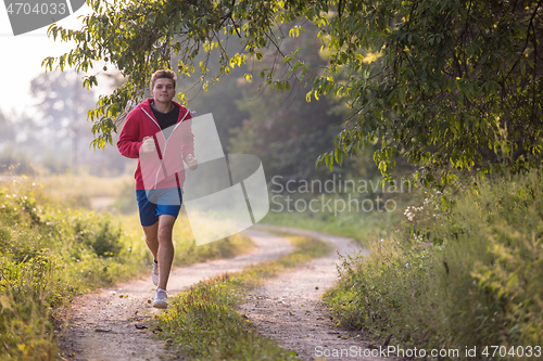 Image of man jogging along a country road