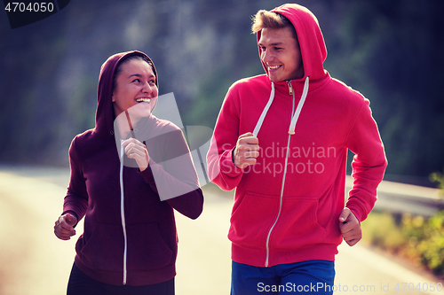 Image of young couple jogging along a country road