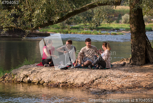 Image of friends smoking hookah on the river bank