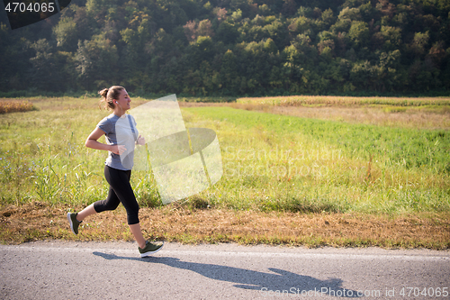 Image of woman jogging along a country road