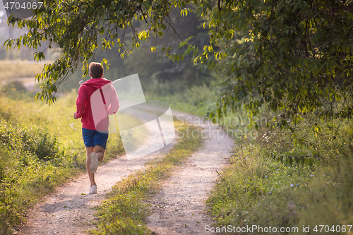 Image of man jogging along a country road