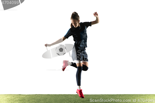 Image of Female soccer player kicking ball isolated over white background