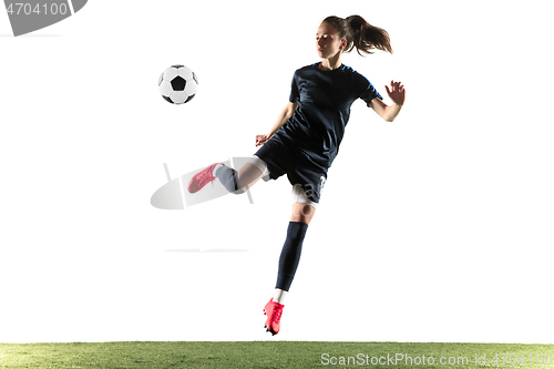 Image of Female soccer player kicking ball isolated over white background