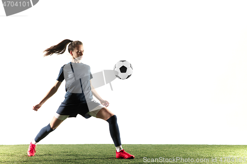 Image of Female soccer player kicking ball isolated over white background