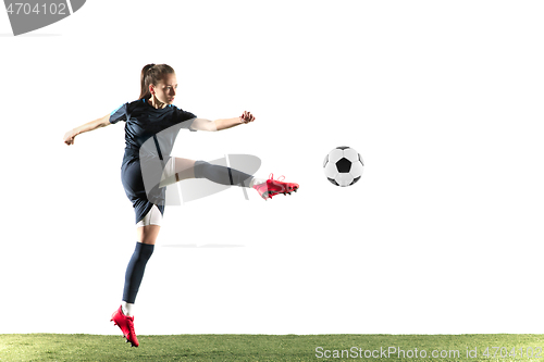 Image of Female soccer player kicking ball isolated over white background