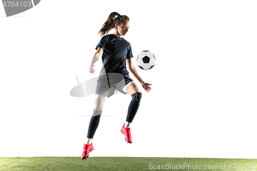 Image of Female soccer player kicking ball isolated over white background