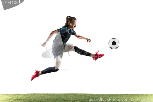 Image of Female soccer player kicking ball isolated over white background