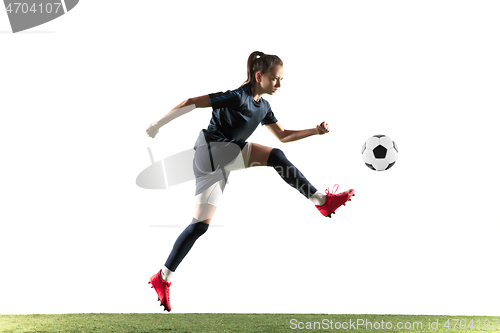 Image of Female soccer player kicking ball isolated over white background