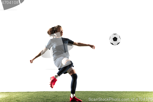 Image of Female soccer player kicking ball isolated over white background