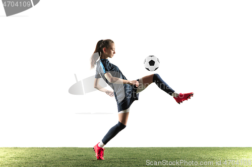 Image of Female soccer player kicking ball isolated over white background