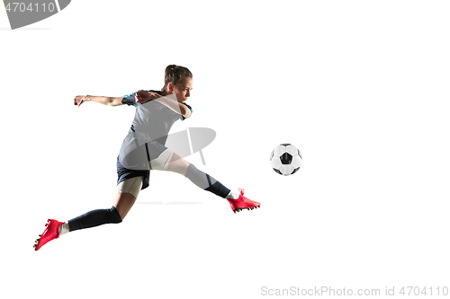 Image of Female soccer player kicking ball isolated over white background