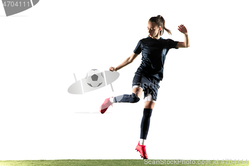 Image of Female soccer player kicking ball isolated over white background