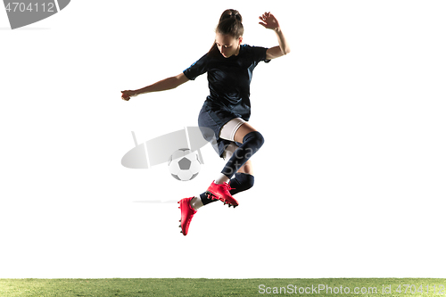 Image of Female soccer player kicking ball isolated over white background