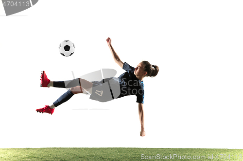 Image of Female soccer player kicking ball isolated over white background