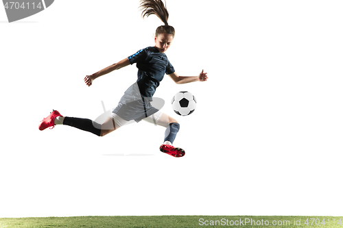 Image of Female soccer player kicking ball isolated over white background