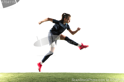 Image of Female soccer player kicking ball isolated over white background