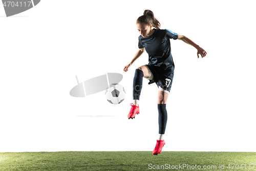 Image of Female soccer player kicking ball isolated over white background