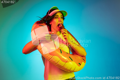 Image of Happy young woman standing and smiling against blue background