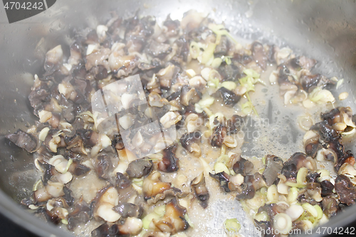 Image of Closeup of eating the fried snails with stalks lemon grass 