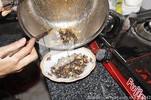 Image of Closeup of eating the fried snails with stalks lemon grass 